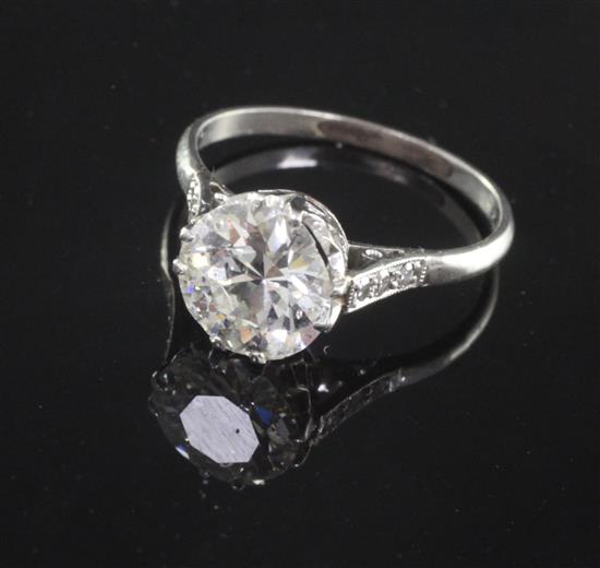 A platinum and single stone diamond ring with diamond set shoulders, size O.